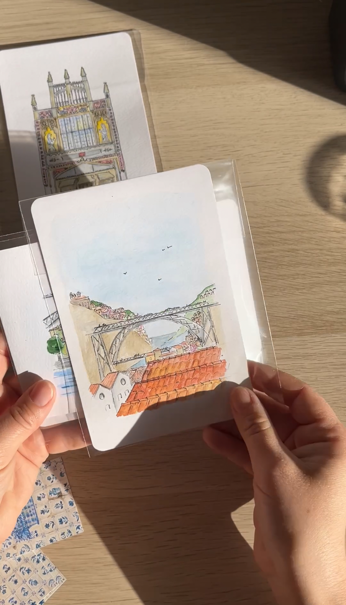 Porto skyline postcard showing the famous bridge, illustrated in soft pastel and watercolor with red roofs in front.